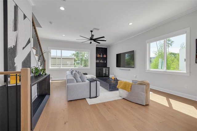 living area with recessed lighting, plenty of natural light, stairs, and light wood-style floors