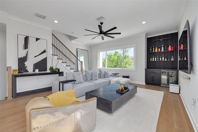 living room featuring wood finished floors, beverage cooler, a dry bar, and visible vents