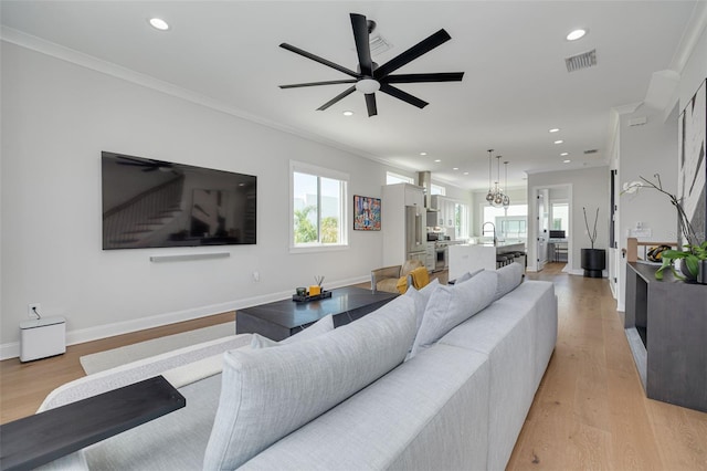 living area featuring a wealth of natural light, light wood finished floors, recessed lighting, and visible vents