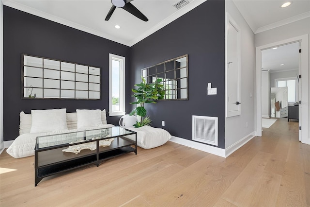 bedroom featuring ornamental molding, baseboards, visible vents, and wood finished floors
