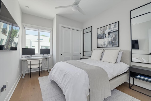 bedroom featuring ceiling fan, a closet, baseboards, and wood finished floors