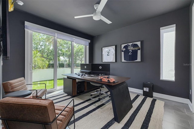 office space with baseboards and a ceiling fan