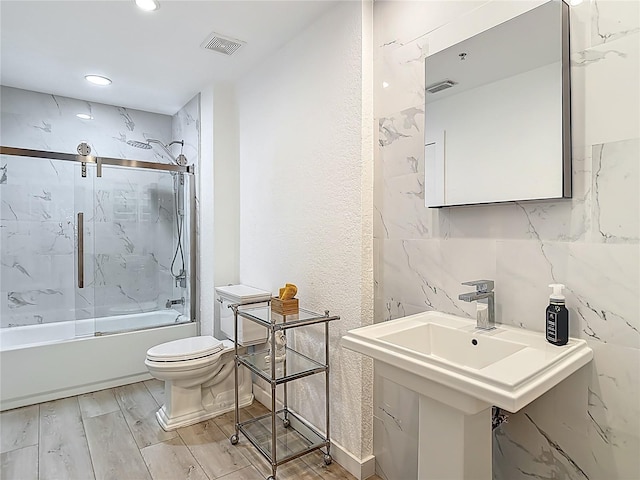 700 S Harbour Island Blvd Unit 143, Tampa, FL 33602 - bathroom featuring toilet, a sink, wood finished floors, enclosed tub / shower combo, and visible vents