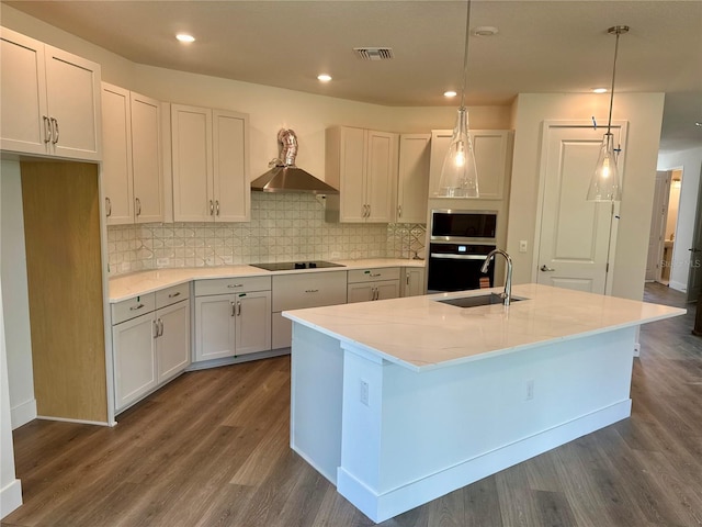 3319 Guanabana Xing, Wesley Chapel, FL 33543 - kitchen featuring dark wood-type flooring, tasteful backsplash, decorative light fixtures, a center island with sink, and recessed lighting