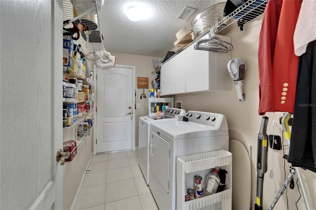 1102 Emerald Dunes Dr, Sun City Center, FL 33573 - laundry area featuring a textured ceiling, light tile patterned flooring, visible vents, cabinet space, and washer and dryer