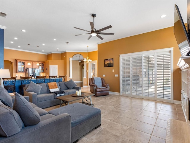 living area with plenty of natural light, ceiling fan with notable chandelier, light tile patterned flooring, and ornamental molding