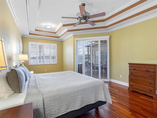 bedroom featuring crown molding, baseboards, a raised ceiling, access to exterior, and wood finished floors