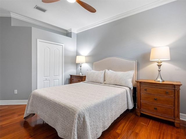 bedroom with baseboards, visible vents, a closet, and wood finished floors