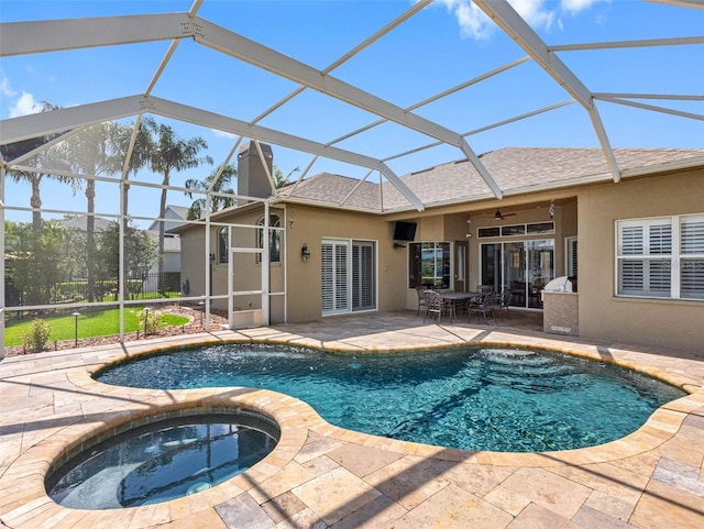 outdoor pool with an in ground hot tub, a lanai, a patio area, and a ceiling fan