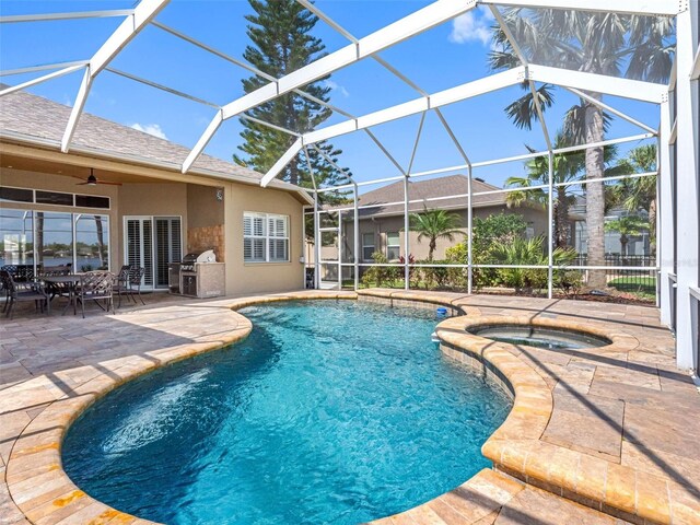 outdoor pool featuring glass enclosure, an in ground hot tub, ceiling fan, and a patio