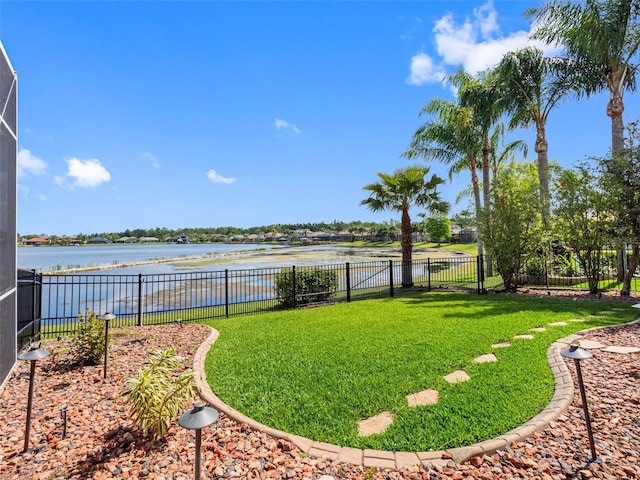 view of yard with a fenced backyard and a water view
