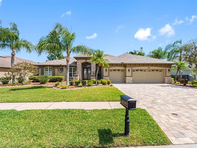 view of front of property with stone siding, stucco siding, a front lawn, decorative driveway, and a garage