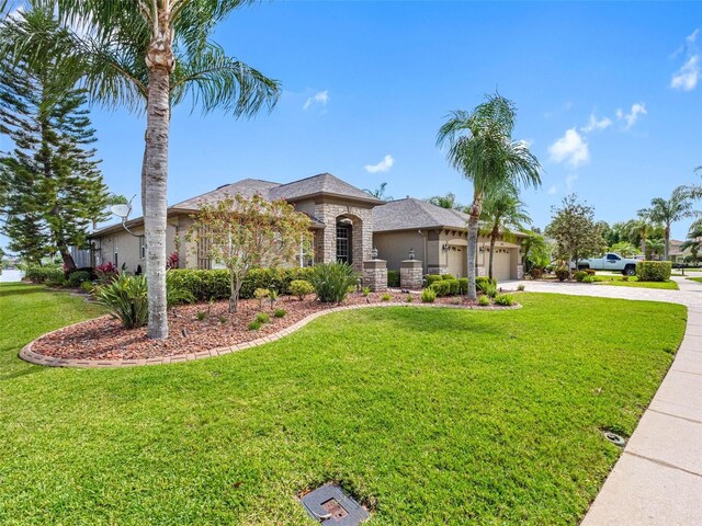 view of front of property featuring a front lawn, driveway, stucco siding, and an attached garage