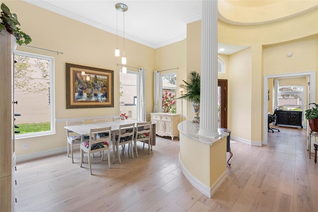 9897 Sago Point Dr, Seminole, FL 33777 - dining area featuring light wood finished floors, a wealth of natural light, decorative columns, and crown molding