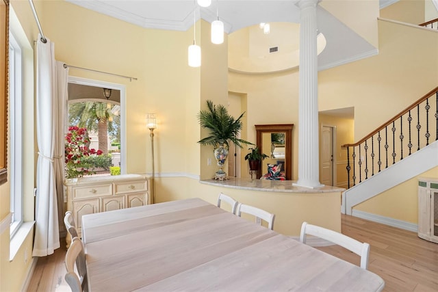 9897 Sago Point Dr, Seminole, FL 33777 - dining space with crown molding, stairs, decorative columns, visible vents, and wood finished floors