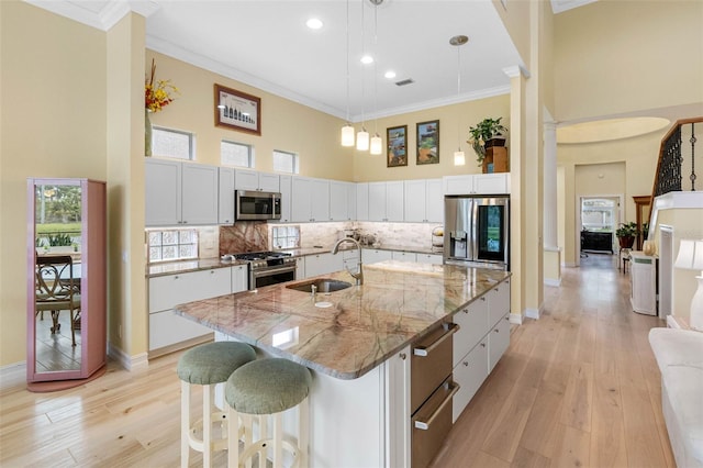 9897 Sago Point Dr, Seminole, FL 33777 - kitchen featuring a sink, ornamental molding, a towering ceiling, and appliances with stainless steel finishes