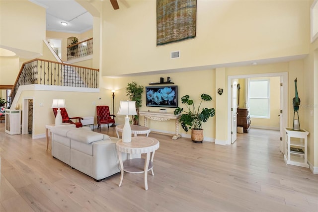 9897 Sago Point Dr, Seminole, FL 33777 - living room with stairs, visible vents, a high ceiling, and wood finished floors