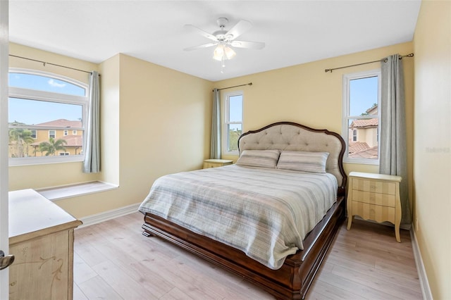 9897 Sago Point Dr, Seminole, FL 33777 - bedroom featuring baseboards, light wood-style flooring, and a ceiling fan