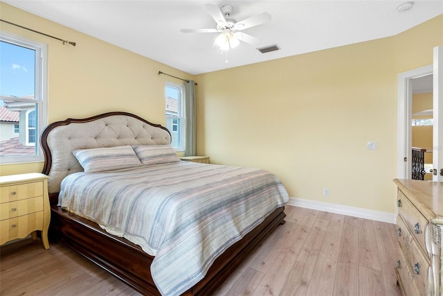 9897 Sago Point Dr, Seminole, FL 33777 - bedroom featuring baseboards, visible vents, light wood-style floors, and a ceiling fan