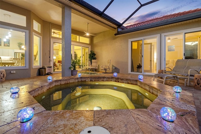 9897 Sago Point Dr, Seminole, FL 33777 - pool at dusk with a lanai, a hot tub, and a patio area