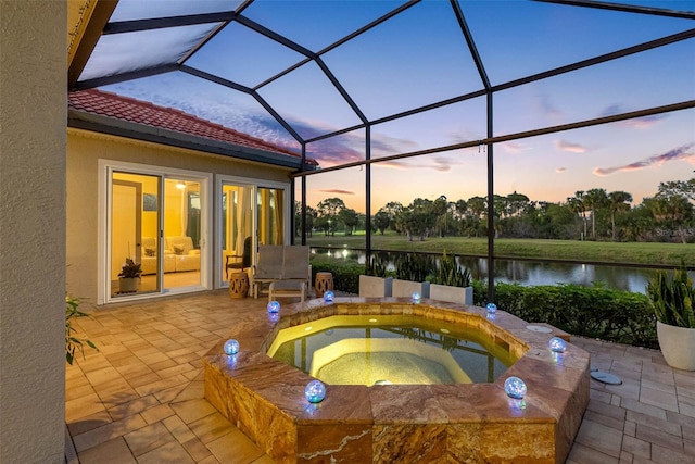 9897 Sago Point Dr, Seminole, FL 33777 - pool at dusk with a lanai, a water view, an in ground hot tub, and a patio area