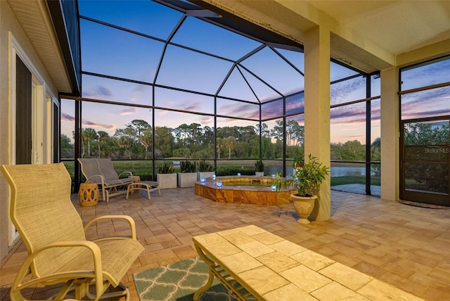 9897 Sago Point Dr, Seminole, FL 33777 - patio terrace at dusk featuring glass enclosure and an in ground hot tub
