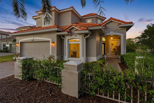 9897 Sago Point Dr, Seminole, FL 33777 - mediterranean / spanish-style home featuring driveway, stucco siding, a tile roof, and a garage
