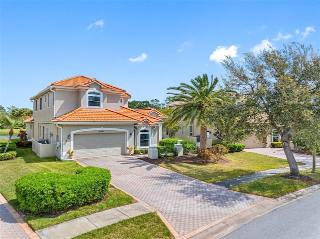 9897 Sago Point Dr, Seminole, FL 33777 - mediterranean / spanish home featuring a front yard, stucco siding, an attached garage, a tiled roof, and decorative driveway
