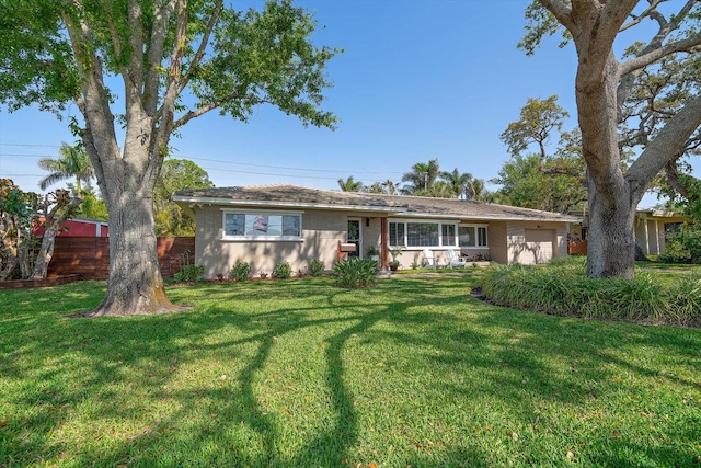 ranch-style home with a front lawn, fence, and a garage