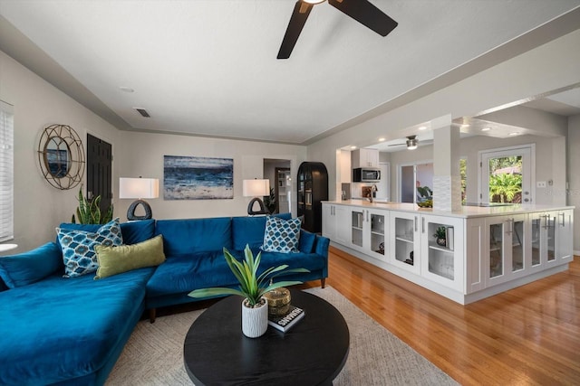 living area with visible vents, light wood-style floors, and ceiling fan