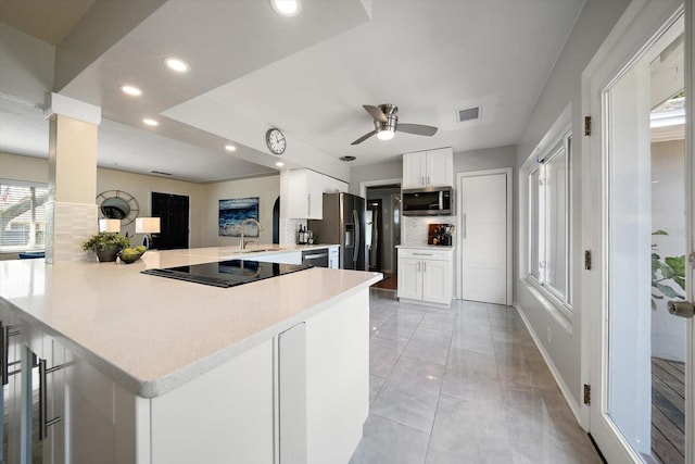 kitchen featuring decorative backsplash, light countertops, visible vents, ceiling fan, and appliances with stainless steel finishes