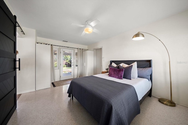 bedroom featuring access to outside, speckled floor, a barn door, visible vents, and a ceiling fan