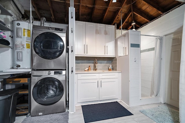 laundry room with water heater, wood ceiling, a sink, stacked washing maching and dryer, and laundry area