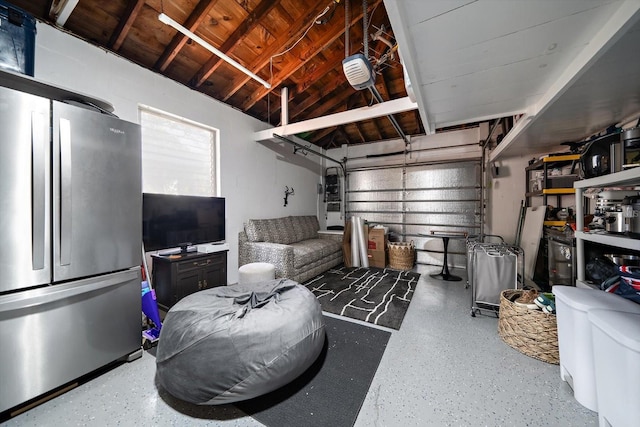 garage with a garage door opener and freestanding refrigerator