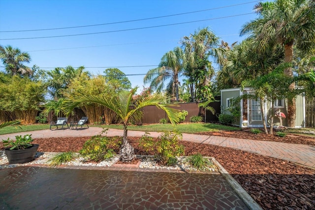 view of yard featuring a fenced backyard, an outdoor structure, and a patio