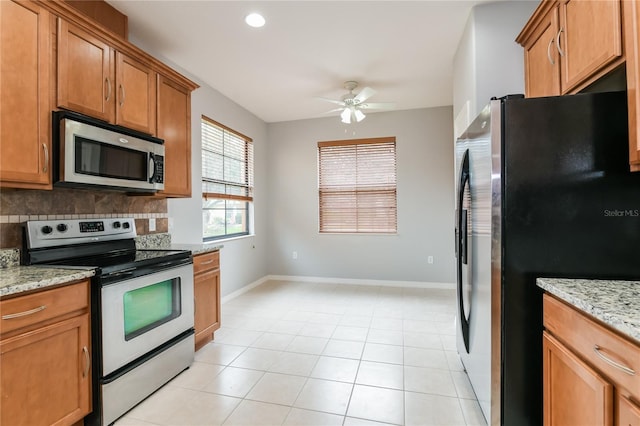 505 Millifiora Ln, Kissimmee, FL 34759 - kitchen with stainless steel appliances, a ceiling fan, tasteful backsplash, brown cabinetry, and baseboards