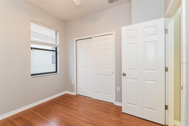 505 Millifiora Ln, Kissimmee, FL 34759 - unfurnished bedroom featuring wood finished floors, baseboards, a closet, and a ceiling fan