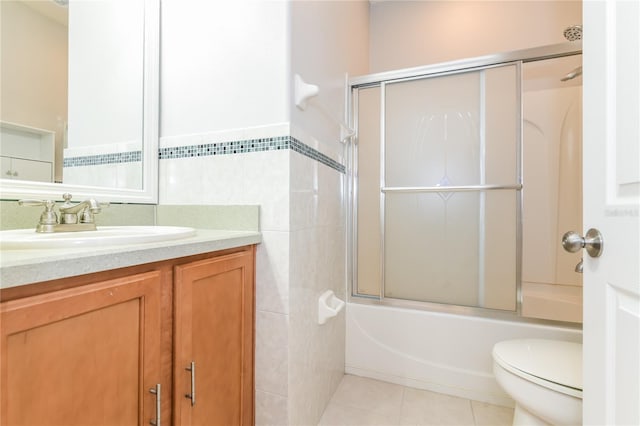 505 Millifiora Ln, Kissimmee, FL 34759 - bathroom with tile walls, vanity, tile patterned floors, toilet, and shower / bath combination with glass door