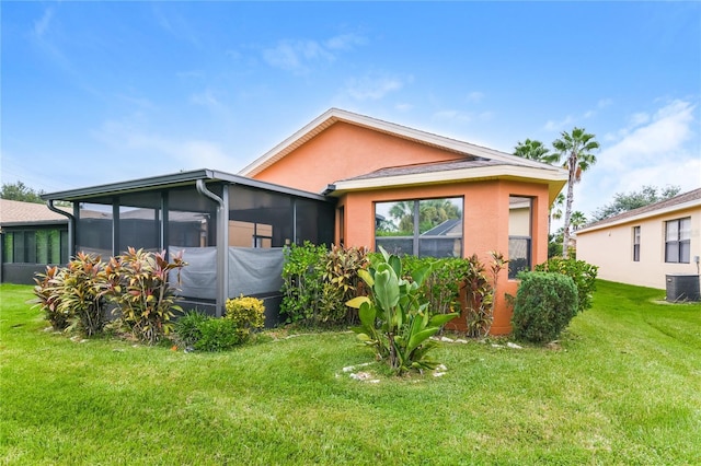 505 Millifiora Ln, Kissimmee, FL 34759 - view of front of house featuring stucco siding, cooling unit, a sunroom, and a front yard