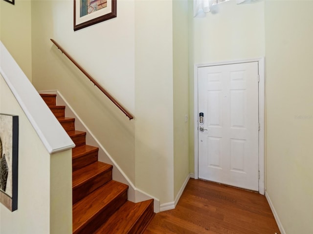 entryway featuring baseboards, stairway, and wood finished floors