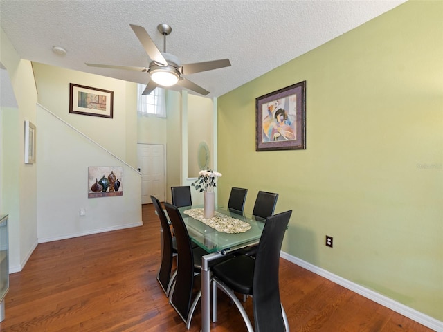 dining area featuring a textured ceiling, wood finished floors, ceiling fan, and baseboards