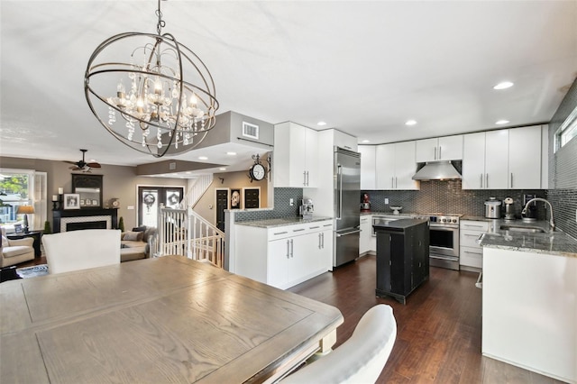 166 E Davis Blvd, Tampa, FL 33606 - kitchen featuring appliances with stainless steel finishes, under cabinet range hood, a sink, a kitchen island, and a fireplace