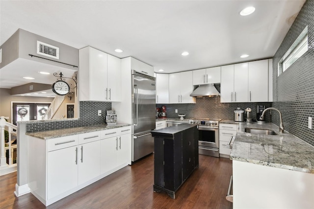 166 E Davis Blvd, Tampa, FL 33606 - kitchen with appliances with stainless steel finishes, under cabinet range hood, a sink, a kitchen island, and decorative backsplash