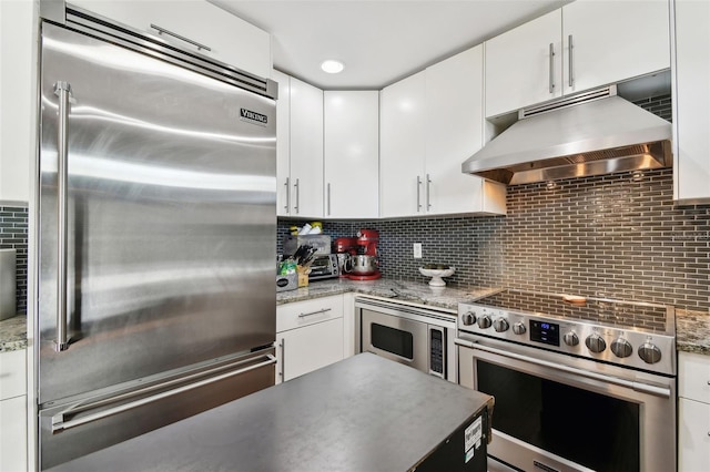 166 E Davis Blvd, Tampa, FL 33606 - kitchen with built in appliances, under cabinet range hood, white cabinets, and backsplash