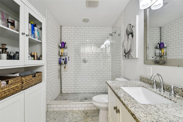 166 E Davis Blvd, Tampa, FL 33606 - bathroom featuring toilet, tiled shower, vanity, and tile patterned flooring