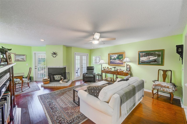 living room featuring a ceiling fan, plenty of natural light, wood finished floors, and a fireplace