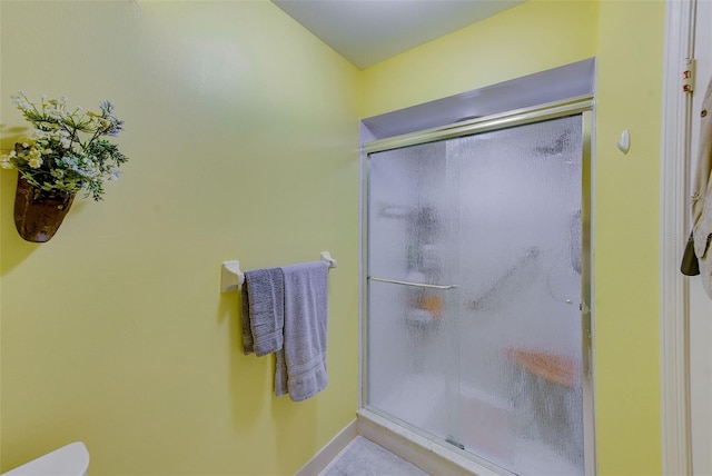 full bathroom with a stall shower and baseboards