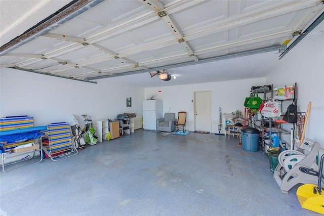 garage with freestanding refrigerator and a garage door opener