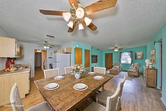 9210 Lehall Sq W, Lakeland, FL 33810 - dining room with a ceiling fan, light wood-style flooring, and a textured ceiling