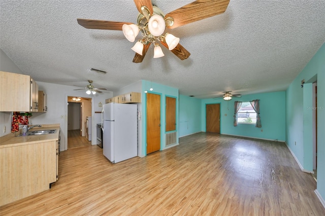 9210 Lehall Sq W, Lakeland, FL 33810 - kitchen with freestanding refrigerator, a sink, a ceiling fan, light wood-style floors, and a textured ceiling